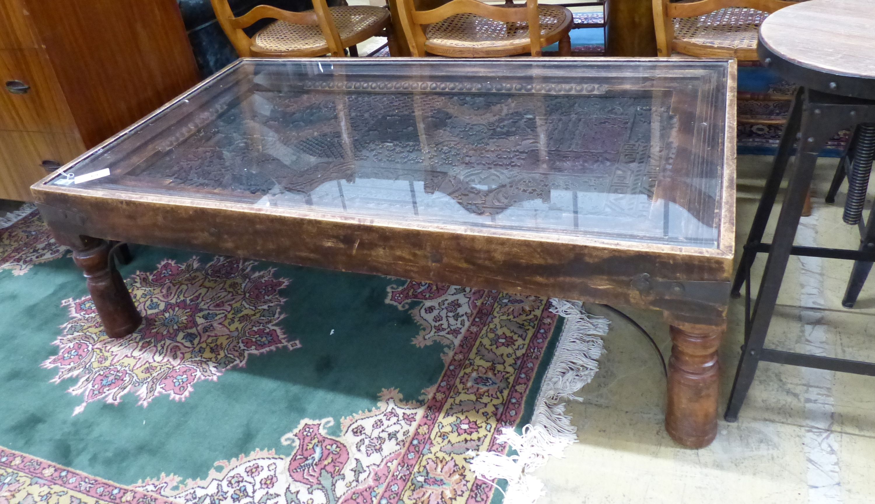 An Indian hardwood coffee table inset with a printing block, length 140cm, width 80cm